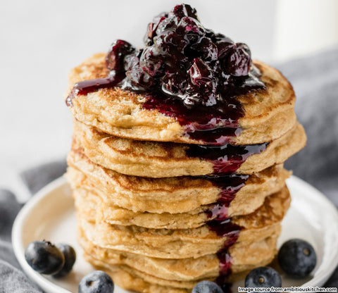 stack of fluffy coconut pancakes with blueberry syrup
